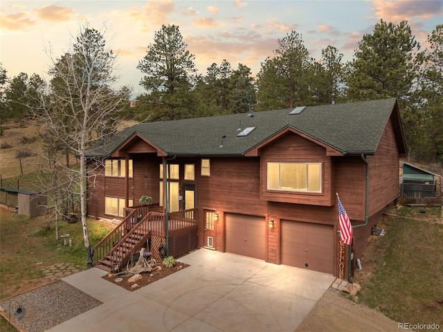 2230 County Road 72, Bailey, CO 80421 - view of front of house featuring a garage, concrete driveway, roof with shingles, and a front yard