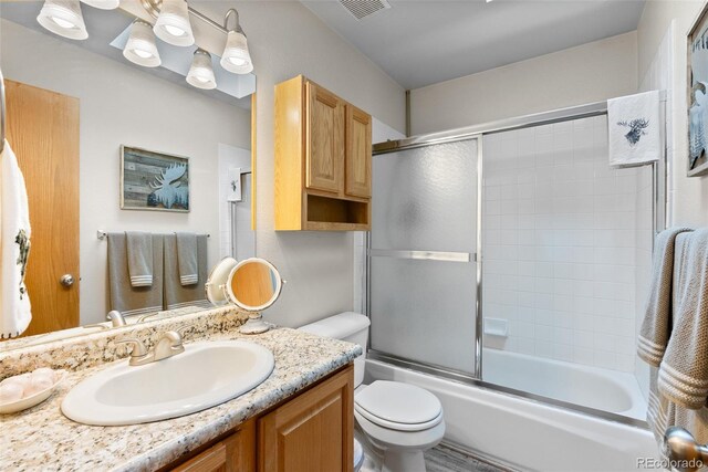 2230 County Road 72, Bailey, CO 80421 - bathroom with toilet, vanity, and bath / shower combo with glass door