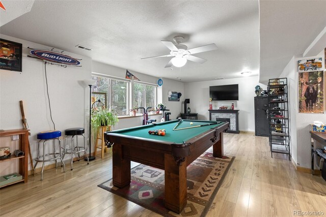 2230 County Road 72, Bailey, CO 80421 - recreation room with a ceiling fan, a fireplace, light wood finished floors, pool table, and a textured ceiling