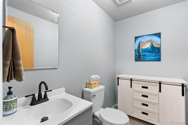 2230 County Road 72, Bailey, CO 80421 - half bathroom with toilet, vanity, and a textured wall