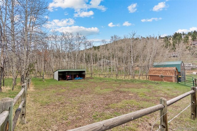2230 County Road 72, Bailey, CO 80421 - view of yard with an outdoor structure, fence, a pole building, a view of trees, and a view of rural / pastoral area