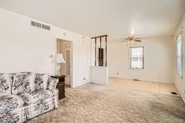 living area featuring visible vents, ceiling fan, and carpet