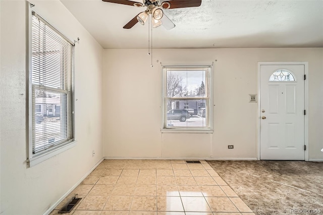 entryway with light tile patterned flooring, baseboards, and visible vents