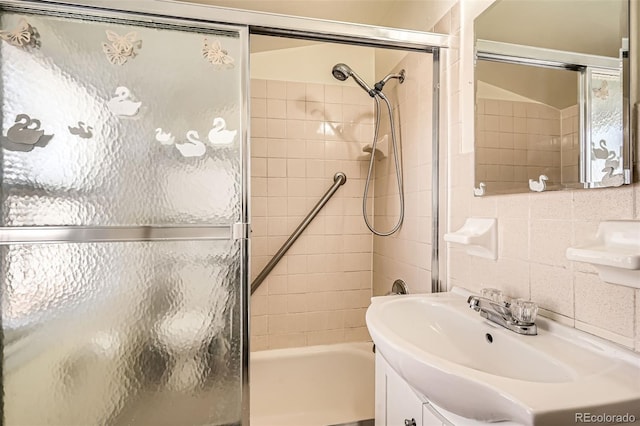 bathroom with bath / shower combo with glass door and a sink