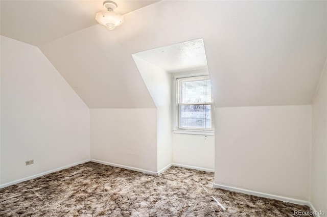 bonus room featuring vaulted ceiling, carpet flooring, and baseboards