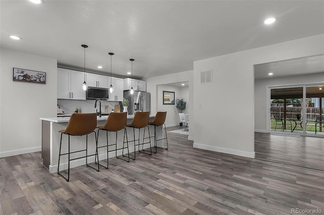 kitchen with visible vents, stainless steel refrigerator with ice dispenser, dark wood-style floors, and recessed lighting
