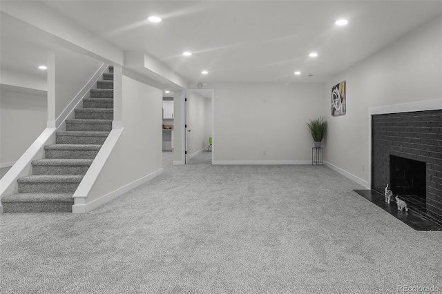 unfurnished living room with stairway, carpet, a fireplace, and recessed lighting