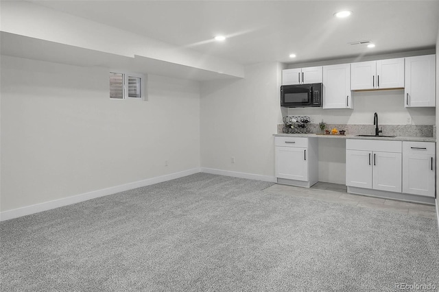 kitchen with white cabinets, black microwave, a sink, recessed lighting, and baseboards