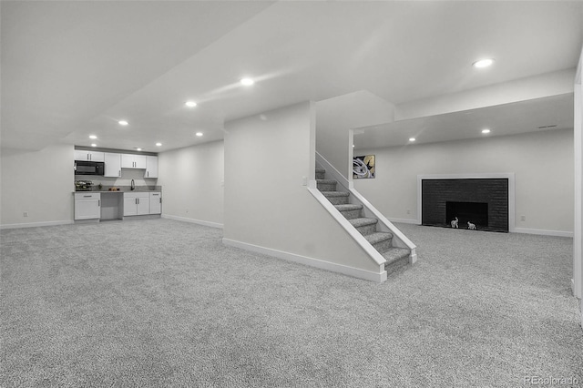 finished basement with light carpet, a fireplace, baseboards, stairway, and recessed lighting