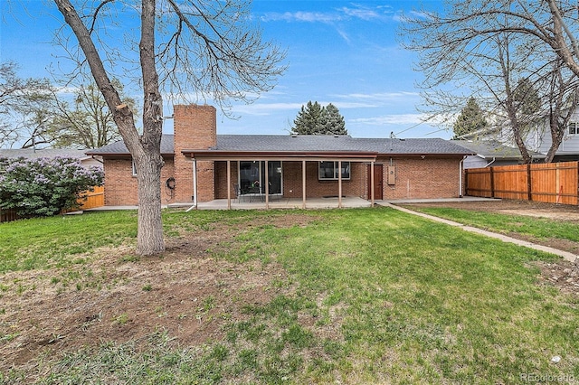 back of house featuring a fenced backyard, a patio, a chimney, and brick siding