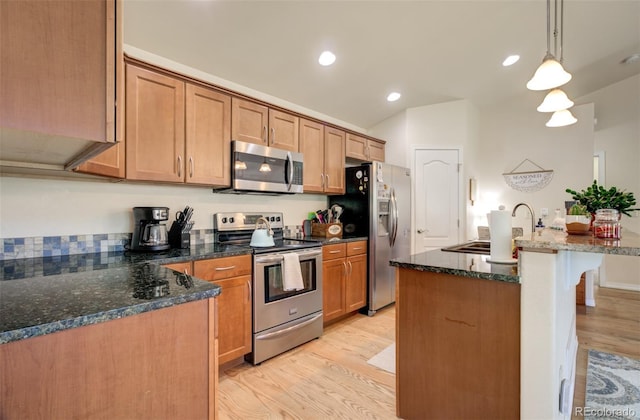 418 Hilltop Cir, Colorado Springs, CO 80905 - kitchen with appliances with stainless steel finishes, light wood-style flooring, decorative light fixtures, a kitchen breakfast bar, and dark stone countertops