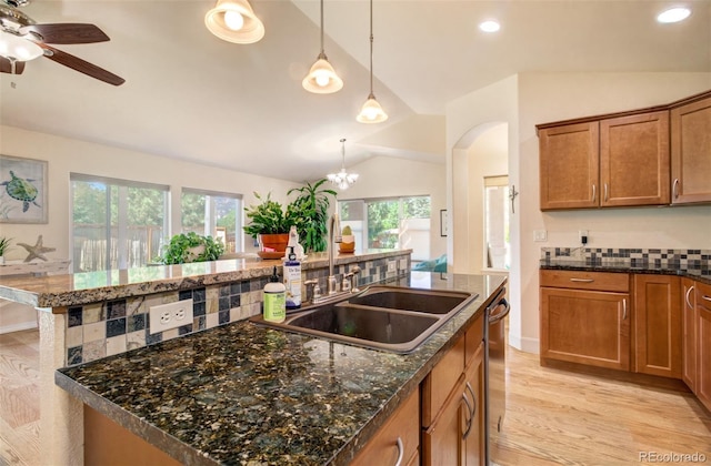 418 Hilltop Cir, Colorado Springs, CO 80905 - kitchen featuring vaulted ceiling, an island with sink, stainless steel dishwasher, healthy amount of natural light, and brown cabinets