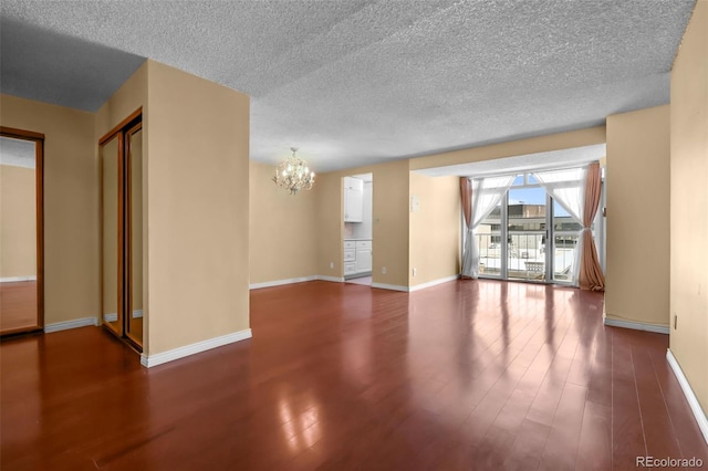 2 Adams St Unit 1507, Denver, CO 80206 - unfurnished living room featuring a chandelier, wood finished floors, a textured ceiling, and baseboards