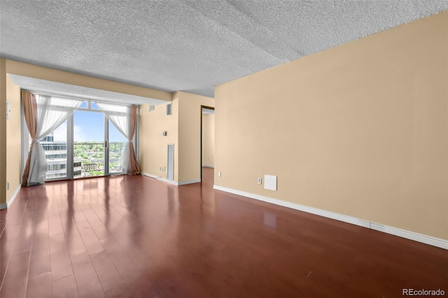 2 Adams St Unit 1507, Denver, CO 80206 - empty room featuring wood finished floors, baseboards, and a textured ceiling