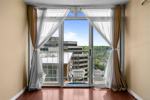 2 Adams St Unit 1507, Denver, CO 80206 - doorway with wood finished floors, baseboards, a wall of windows, and a city view