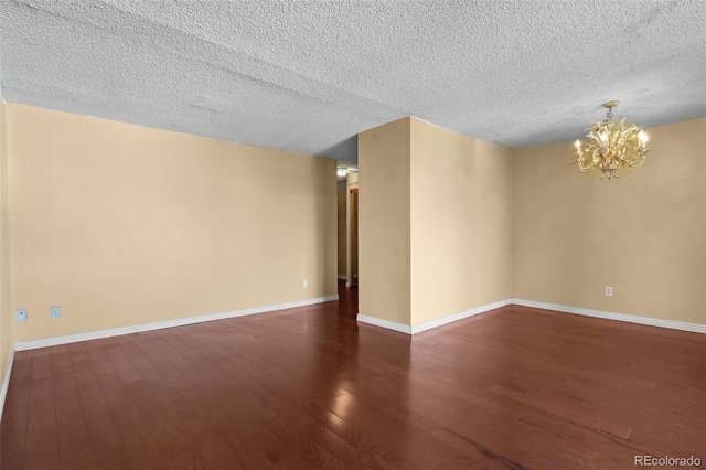 2 Adams St Unit 1507, Denver, CO 80206 - unfurnished room featuring a chandelier, wood finished floors, a textured ceiling, and baseboards