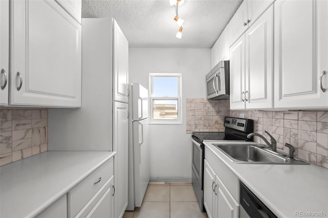 2 Adams St Unit 1507, Denver, CO 80206 - kitchen featuring appliances with stainless steel finishes, a sink, white cabinetry, tasteful backsplash, and a textured ceiling