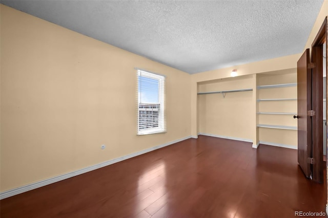 2 Adams St Unit 1507, Denver, CO 80206 - unfurnished bedroom with a textured ceiling, a closet, dark wood-type flooring, and baseboards