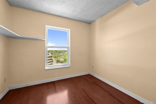2 Adams St Unit 1507, Denver, CO 80206 - unfurnished room featuring baseboards, wood finished floors, and a textured ceiling