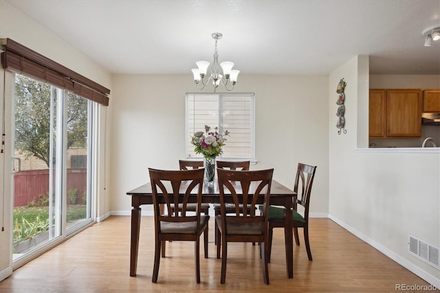 dining area featuring an inviting chandelier and light hardwood / wood-style floors