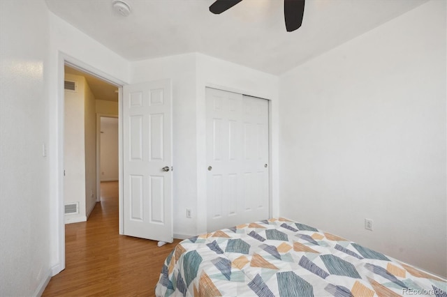 bedroom featuring ceiling fan, a closet, and hardwood / wood-style flooring