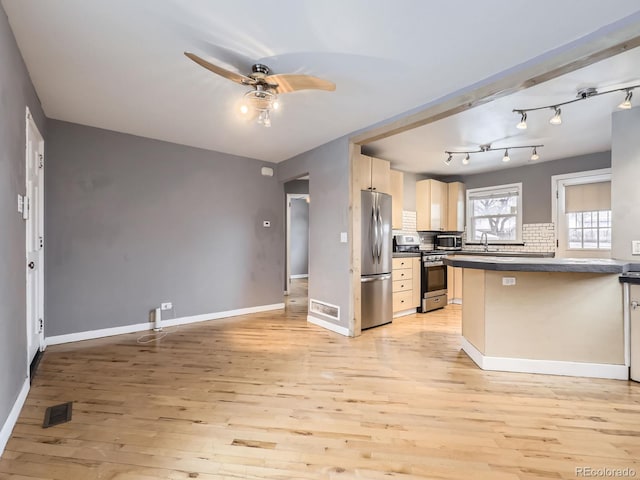 kitchen featuring light brown cabinetry, tasteful backsplash, ceiling fan, stainless steel appliances, and light wood-type flooring