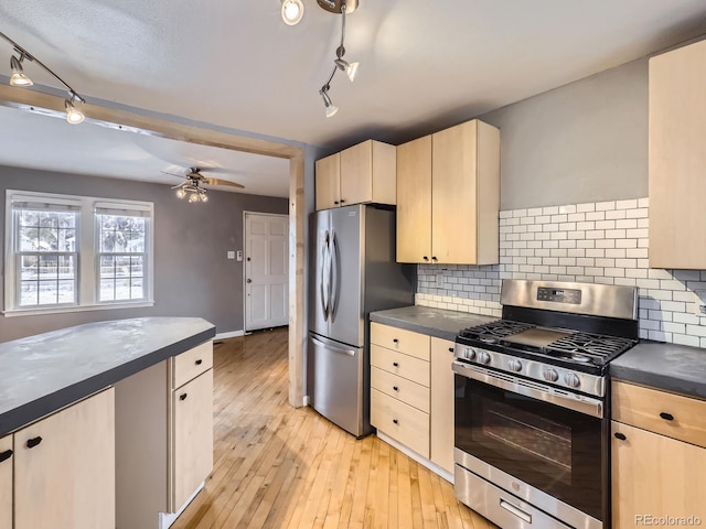 kitchen featuring decorative backsplash, light hardwood / wood-style flooring, stainless steel appliances, and ceiling fan