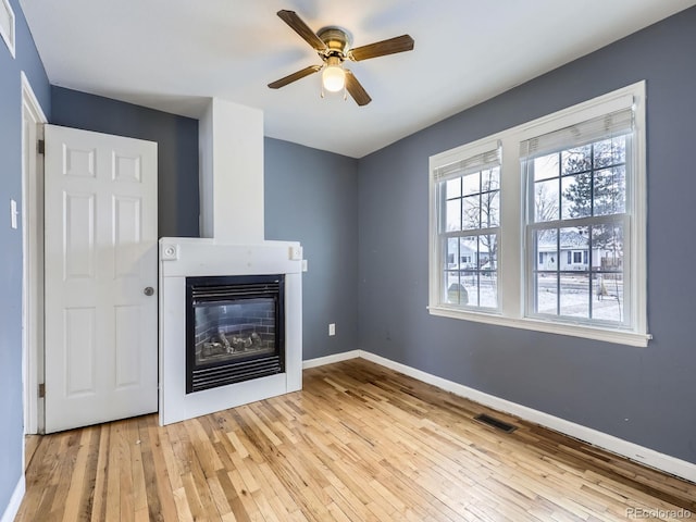 unfurnished living room with ceiling fan and light hardwood / wood-style floors