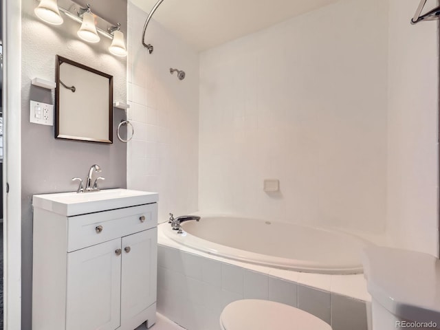 full bathroom featuring tiled shower / bath combo, vanity, and toilet