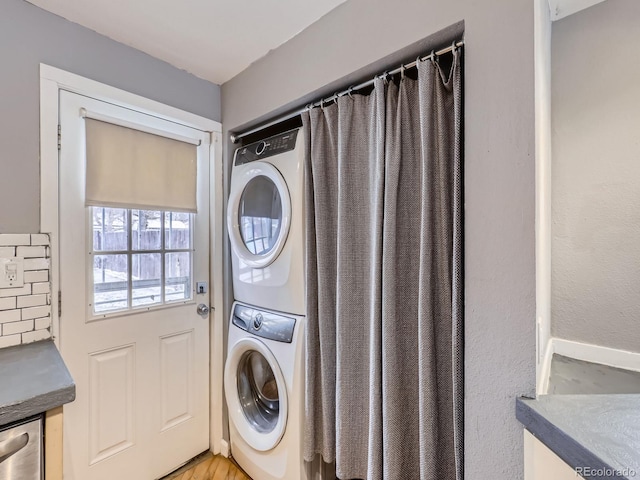 washroom featuring stacked washer / dryer