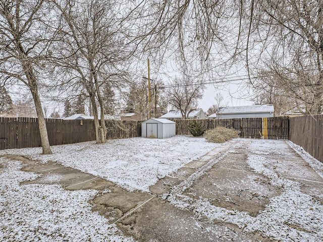 snowy yard featuring a storage shed