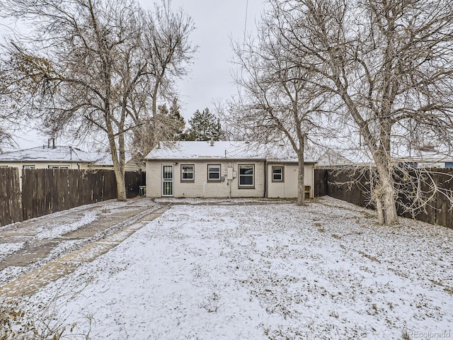 view of snow covered back of property