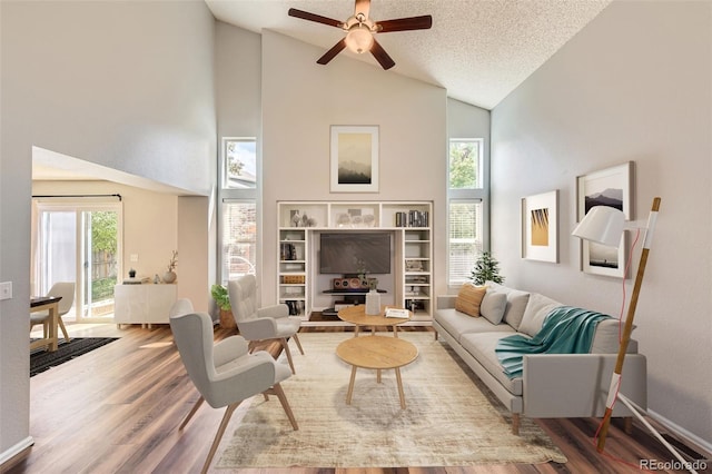 8750 Redwing Ave, Littleton, CO 80126 - living room with ceiling fan, wood finished floors, high vaulted ceiling, and a textured ceiling