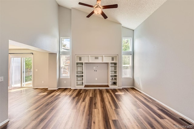 8750 Redwing Ave, Littleton, CO 80126 - unfurnished living room featuring high vaulted ceiling, wood finished floors, ceiling fan, baseboards, and a textured ceiling