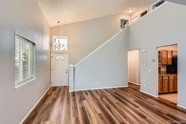 8750 Redwing Ave, Littleton, CO 80126 - foyer featuring high vaulted ceiling, wood finished floors, a chandelier, baseboards, and a textured ceiling