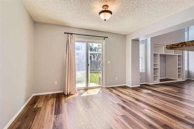 8750 Redwing Ave, Littleton, CO 80126 - empty room with wood finished floors, a textured ceiling, and baseboards
