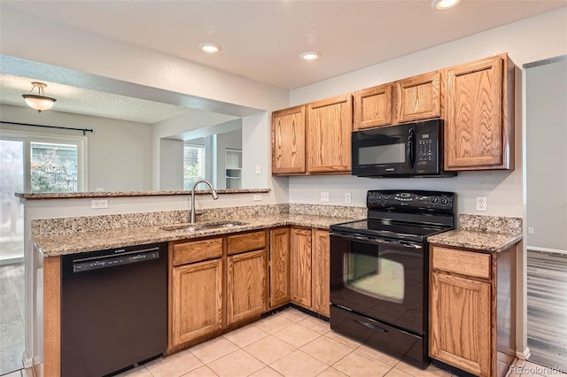 8750 Redwing Ave, Littleton, CO 80126 - kitchen with black appliances, a sink, a peninsula, light stone counters, and recessed lighting
