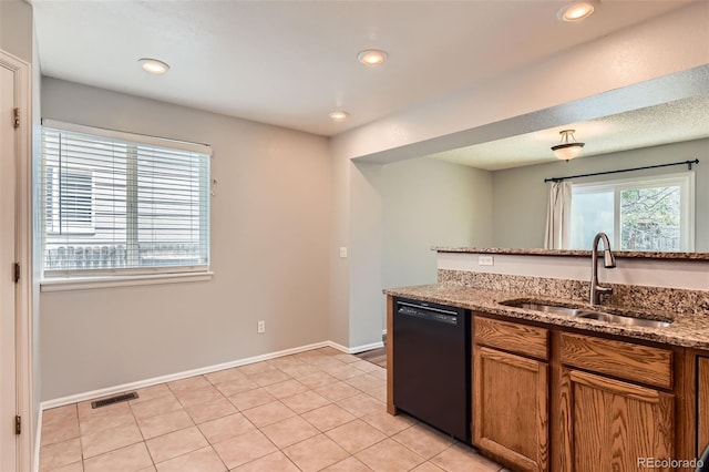 8750 Redwing Ave, Littleton, CO 80126 - kitchen with dishwasher, a sink, brown cabinets, light stone counters, and light tile patterned floors