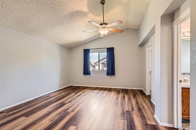 8750 Redwing Ave, Littleton, CO 80126 - unfurnished bedroom featuring dark wood-style floors, a textured ceiling, lofted ceiling, baseboards, and ceiling fan