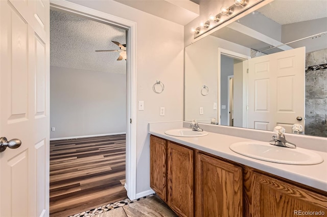 8750 Redwing Ave, Littleton, CO 80126 - full bath featuring double vanity, a textured ceiling, a ceiling fan, and wood finished floors