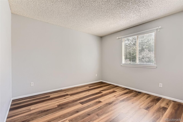 8750 Redwing Ave, Littleton, CO 80126 - spare room featuring wood finished floors, a textured ceiling, and baseboards