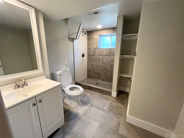 15908 E Flora Pl, Aurora, CO 80013 - full bath featuring toilet, vanity, a tile shower, a textured ceiling, and baseboards
