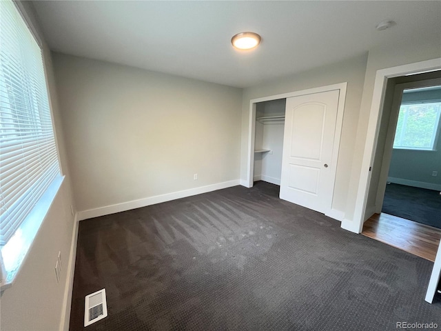 15908 E Flora Pl, Aurora, CO 80013 - unfurnished bedroom featuring dark carpet, baseboards, and a closet