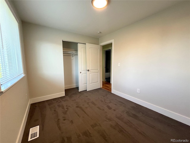 15908 E Flora Pl, Aurora, CO 80013 - unfurnished bedroom with baseboards, a closet, and dark carpet