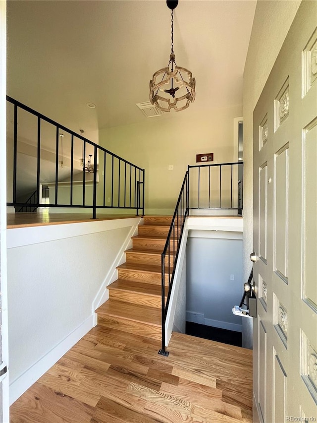 15908 E Flora Pl, Aurora, CO 80013 - stairway featuring wood finished floors, a chandelier, and lofted ceiling