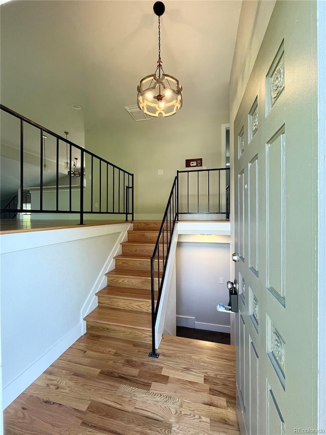 15908 E Flora Pl, Aurora, CO 80013 - foyer entrance featuring a chandelier, stairway, wood finished floors, and baseboards