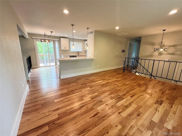 15908 E Flora Pl, Aurora, CO 80013 - unfurnished living room with light wood-style floors, recessed lighting, baseboards, and a sink