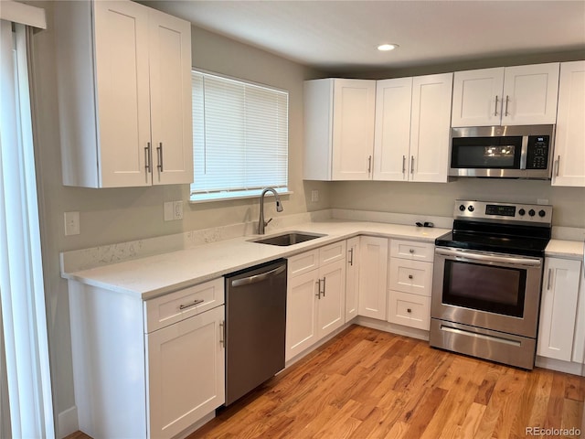 15908 E Flora Pl, Aurora, CO 80013 - kitchen with appliances with stainless steel finishes, a sink, white cabinetry, light countertops, and recessed lighting