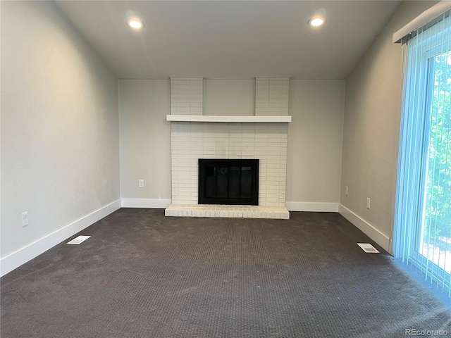 15908 E Flora Pl, Aurora, CO 80013 - unfurnished living room featuring dark carpet, healthy amount of natural light, a fireplace, baseboards, and recessed lighting
