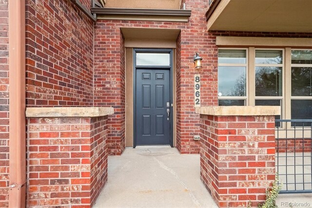 view of exterior entry featuring brick siding